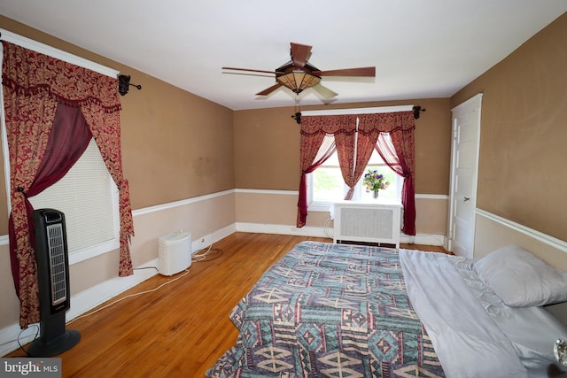 bedroom with wood finished floors, ceiling fan, and baseboards