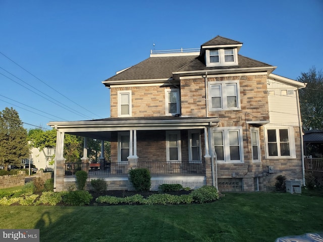 view of front of property featuring covered porch, a front yard, stone siding, and a shingled roof