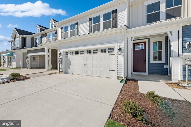 multi unit property featuring a garage and concrete driveway