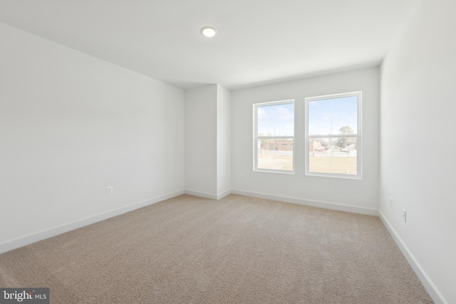 empty room with light colored carpet, baseboards, and recessed lighting