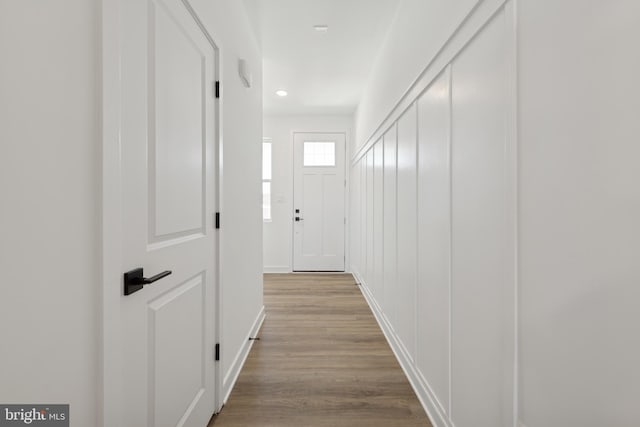 hall with wood finished floors, baseboards, and recessed lighting