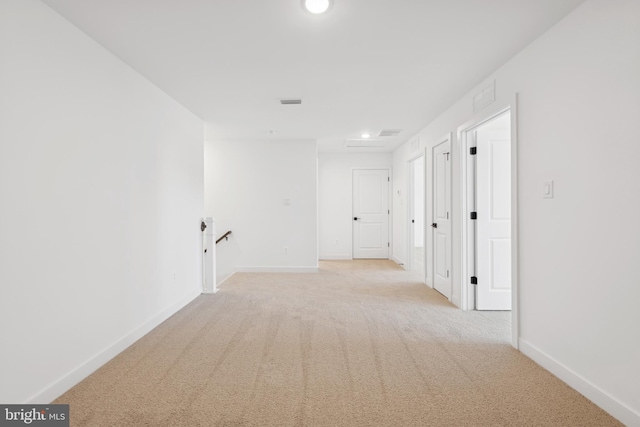 hallway featuring an upstairs landing, light colored carpet, baseboards, and recessed lighting