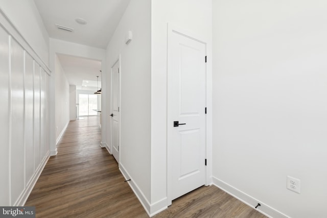 hall featuring wood finished floors and baseboards