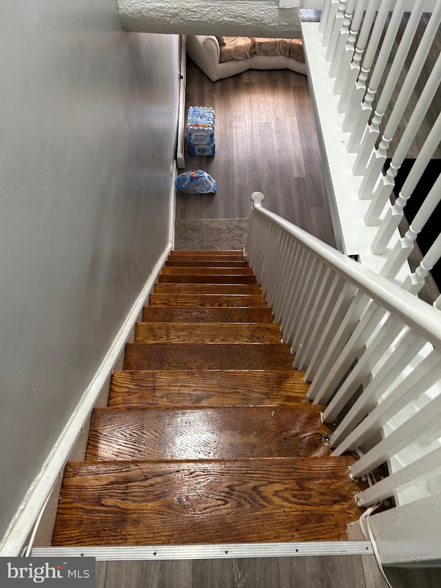 staircase with hardwood / wood-style floors