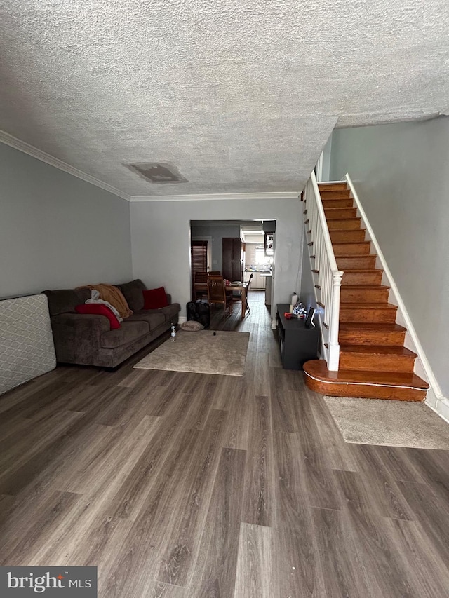 living room featuring stairs, wood finished floors, a textured ceiling, and crown molding