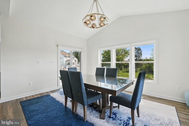 dining room featuring a chandelier, wood finished floors, baseboards, and high vaulted ceiling