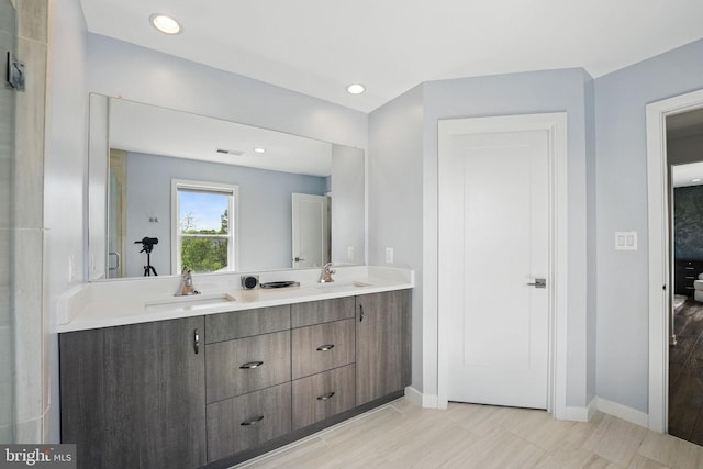 full bath with baseboards and double vanity