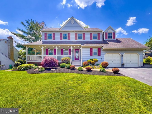 view of front of property featuring a porch, driveway, a front lawn, and an attached garage
