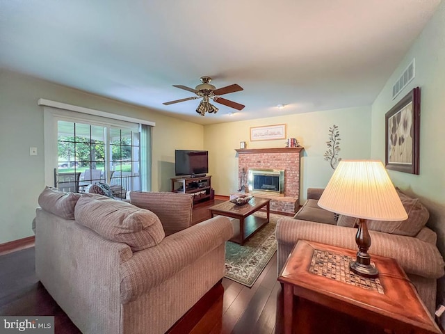 living area with wood finished floors, a ceiling fan, a fireplace, and baseboards