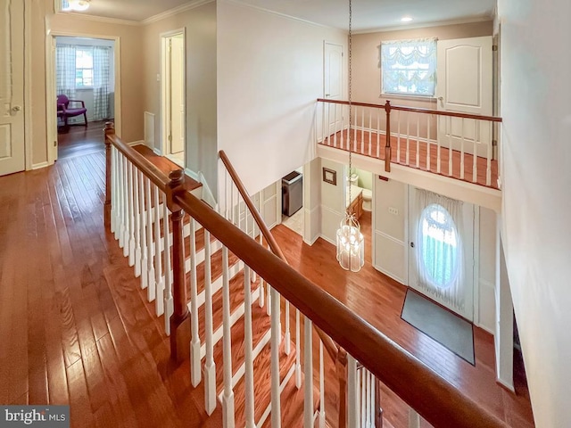 stairs featuring ornamental molding, hardwood / wood-style flooring, and baseboards