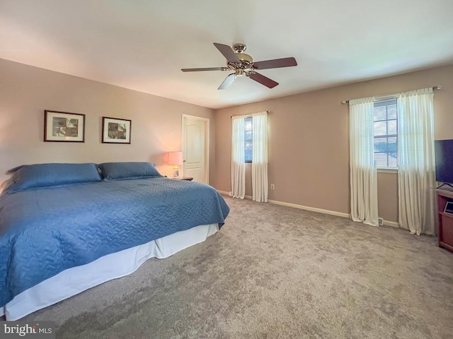 carpeted bedroom featuring baseboards and a ceiling fan