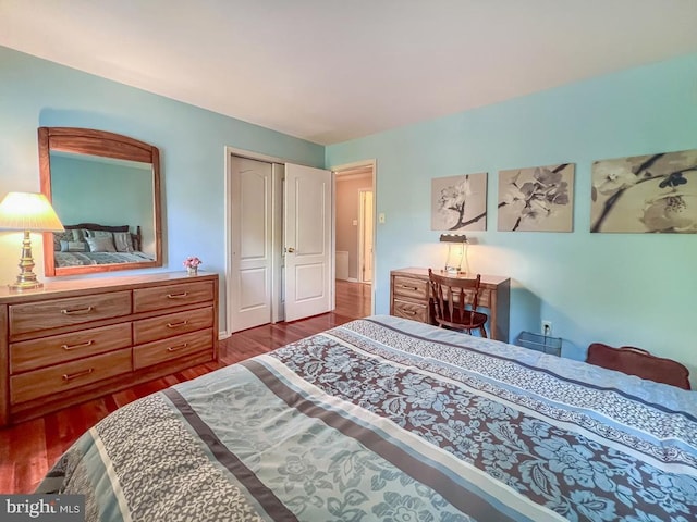 bedroom with dark wood-type flooring and a closet