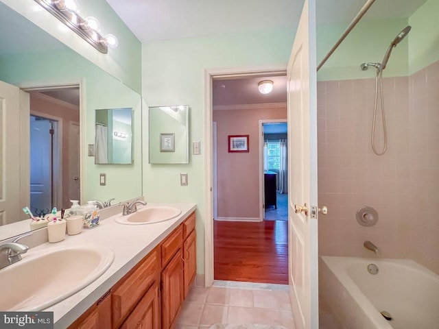 full bath with ornamental molding, tile patterned floors, double vanity,  shower combination, and baseboards