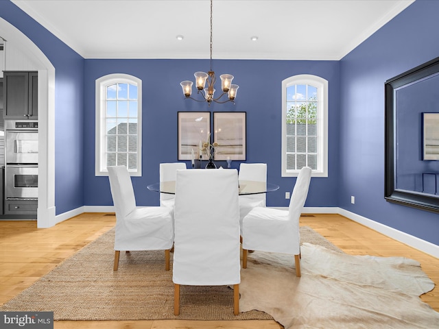 7839 Denton Ave, Baltimore, MD 21219 - dining area with a chandelier, wood finished floors, ornamental molding, baseboards, and arched walkways
