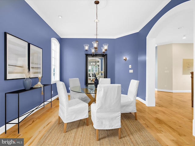7839 Denton Ave, Baltimore, MD 21219 - dining area with a chandelier, arched walkways, wood finished floors, baseboards, and ornamental molding