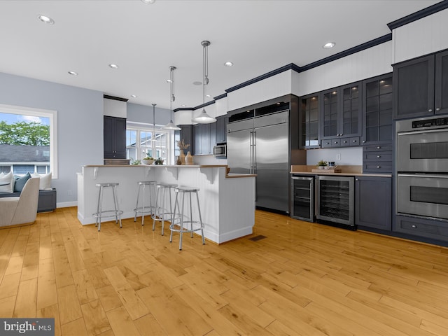 7839 Denton Ave, Baltimore, MD 21219 - kitchen featuring beverage cooler, appliances with stainless steel finishes, a breakfast bar area, plenty of natural light, and recessed lighting