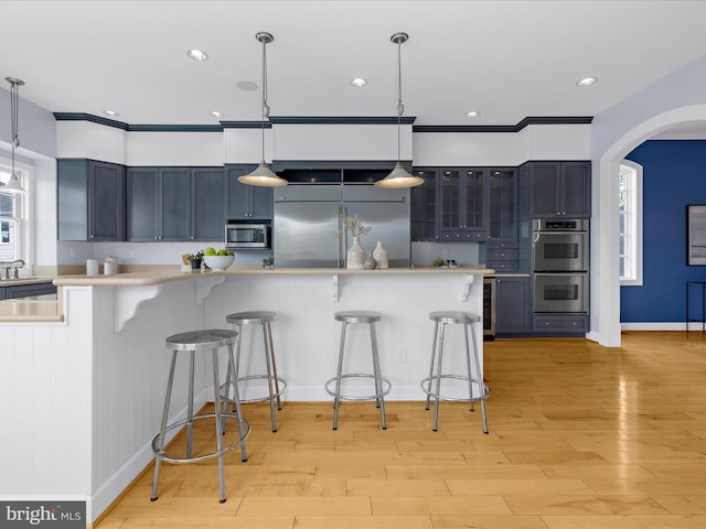 7839 Denton Ave, Baltimore, MD 21219 - kitchen with stainless steel appliances, a kitchen breakfast bar, arched walkways, light countertops, and recessed lighting