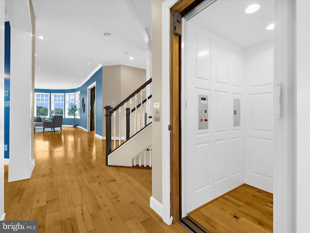 7839 Denton Ave, Baltimore, MD 21219 - hallway with elevator, light wood finished floors, stairway, baseboards, and recessed lighting