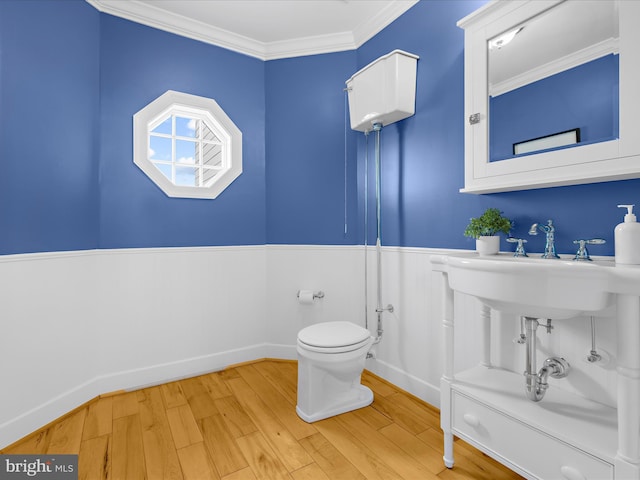 7839 Denton Ave, Baltimore, MD 21219 - bathroom featuring wainscoting, wood finished floors, toilet, crown molding, and baseboards