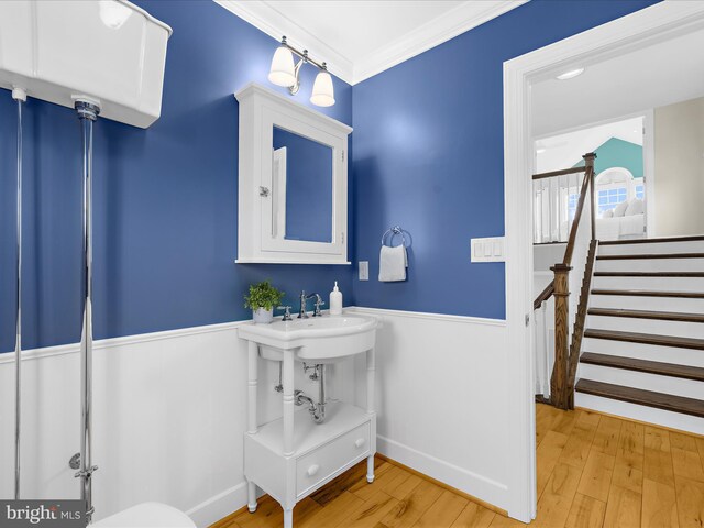 7839 Denton Ave, Baltimore, MD 21219 - half bath featuring a wainscoted wall, wood finished floors, and crown molding