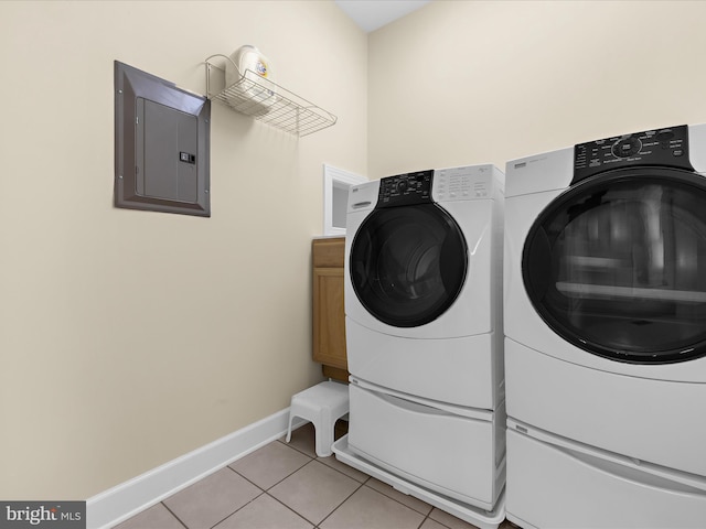 7839 Denton Ave, Baltimore, MD 21219 - laundry room featuring electric panel, baseboards, washing machine and clothes dryer, light tile patterned floors, and cabinet space
