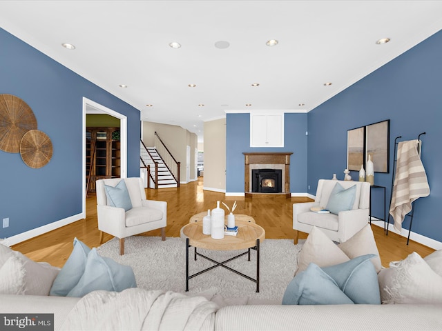 7839 Denton Ave, Baltimore, MD 21219 - living room with wood finished floors, stairs, a warm lit fireplace, baseboards, and recessed lighting