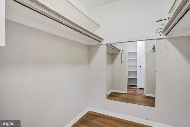 walk in closet with wood finished floors