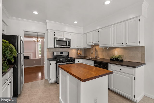 4849 Carriagepark Rd, Fairfax, VA 22032 - kitchen with stainless steel appliances, a sink, wood counters, a chandelier, and white cabinets