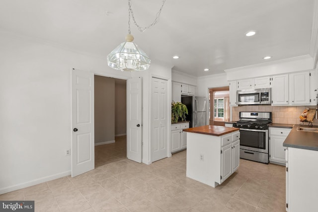 4849 Carriagepark Rd, Fairfax, VA 22032 - kitchen with stainless steel appliances, a kitchen island, crown molding, white cabinets, and tasteful backsplash