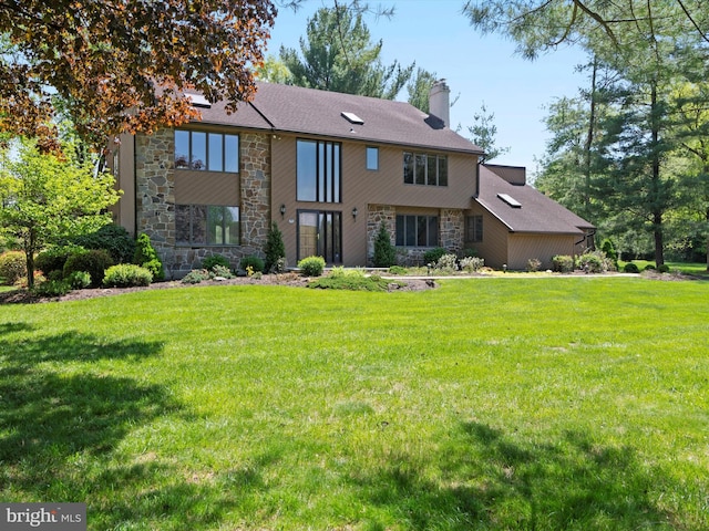 view of front of home featuring stone siding, a chimney, and a front lawn