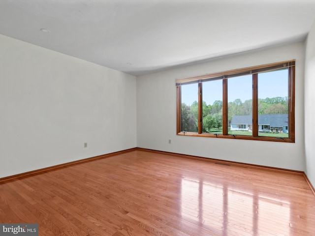 empty room with light wood-style floors and baseboards