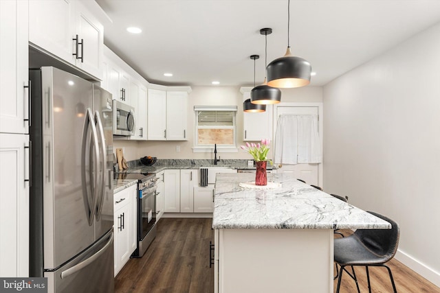 203 Coville Dr, Browns Mills, NJ 08015 - kitchen with stainless steel appliances, dark wood-style flooring, a kitchen island, a breakfast bar area, and white cabinets