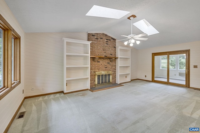 7 Spoon Ter, Palmyra, VA 22963 - unfurnished living room featuring a skylight, lofted ceiling, baseboards, a fireplace, and carpet
