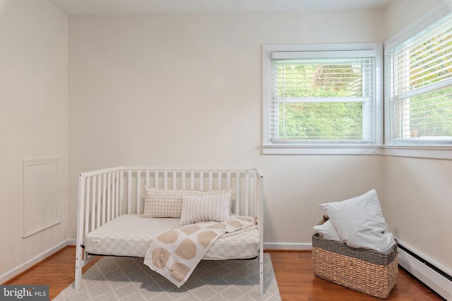 1808 Bay Ridge Ave, Annapolis, MD 21403 - bedroom featuring baseboard heating, multiple windows, wood finished floors, and baseboards