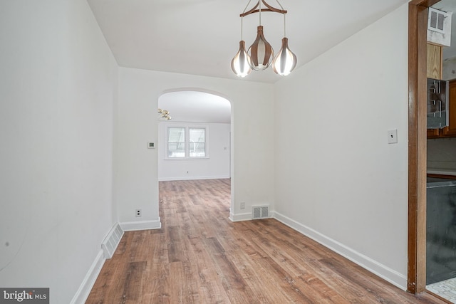 3311 Meridian St, Philadelphia, PA 19136 - unfurnished dining area with arched walkways, wood finished floors, a chandelier, and baseboards