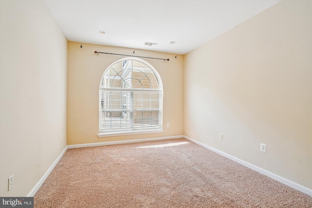spare room featuring carpet flooring and baseboards