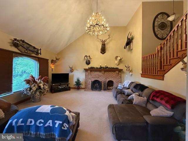 15920 River Bend Ct, Williamsport, MD 21795 - carpeted living room featuring stairway, a chandelier, a brick fireplace, and high vaulted ceiling