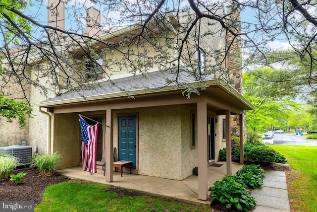 1644 Spring Mill Ct, Yardley, PA 19067 - rear view of house with stucco siding, a chimney, and central AC unit