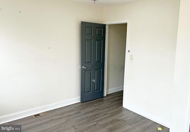 spare room featuring wood finished floors and baseboards