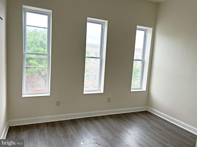 empty room with dark wood finished floors and baseboards