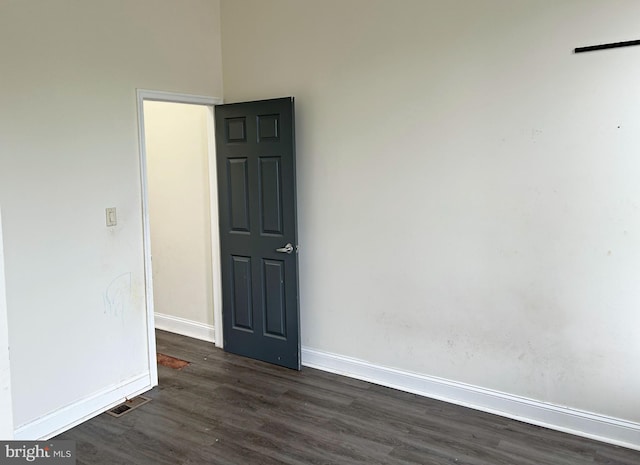 unfurnished room with dark wood-style floors and baseboards