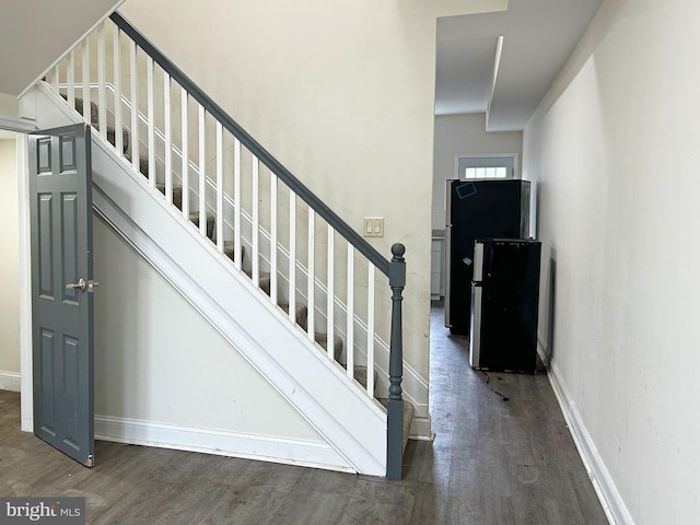 stairs featuring wood finished floors and baseboards