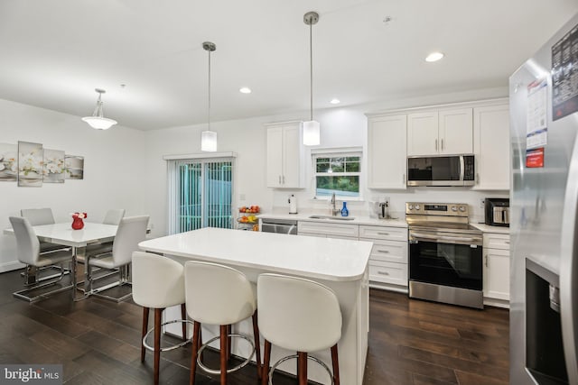 4202 Louisa Ave, Nottingham, MD 21236 - kitchen with stainless steel appliances, a sink, dark wood finished floors, light countertops, and a breakfast bar area