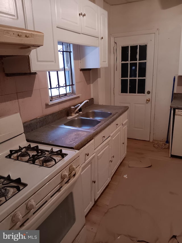 kitchen featuring white appliances, a sink, white cabinetry, and under cabinet range hood