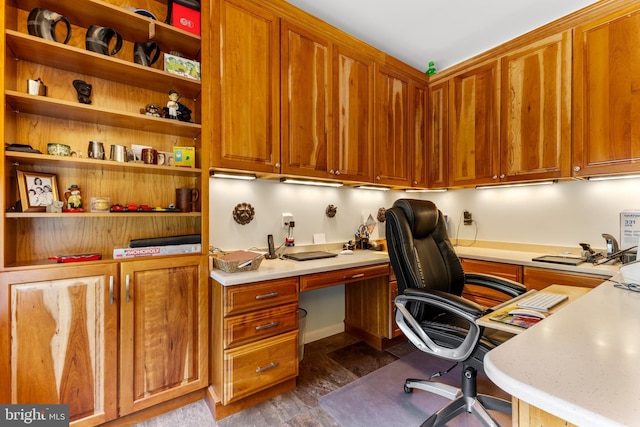 office with dark wood finished floors and built in study area