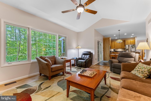 living room featuring light wood-style floors, a ceiling fan, baseboards, recessed lighting, and vaulted ceiling
