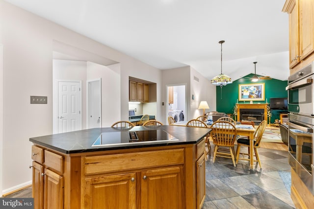 kitchen with black electric stovetop, dark countertops, open floor plan, a fireplace, and vaulted ceiling
