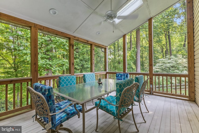 sunroom / solarium featuring a ceiling fan, outdoor dining area, and vaulted ceiling