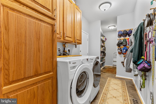 clothes washing area featuring cabinet space, separate washer and dryer, and baseboards
