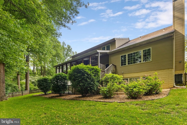 back of property featuring a chimney, brick siding, and central AC unit